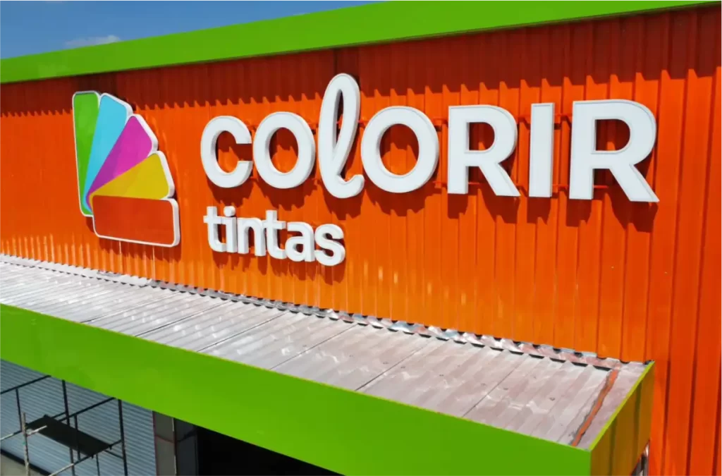 Fachada comercial moderna em ACM com design diferenciado e iluminação LED, destacando a marca da empresa